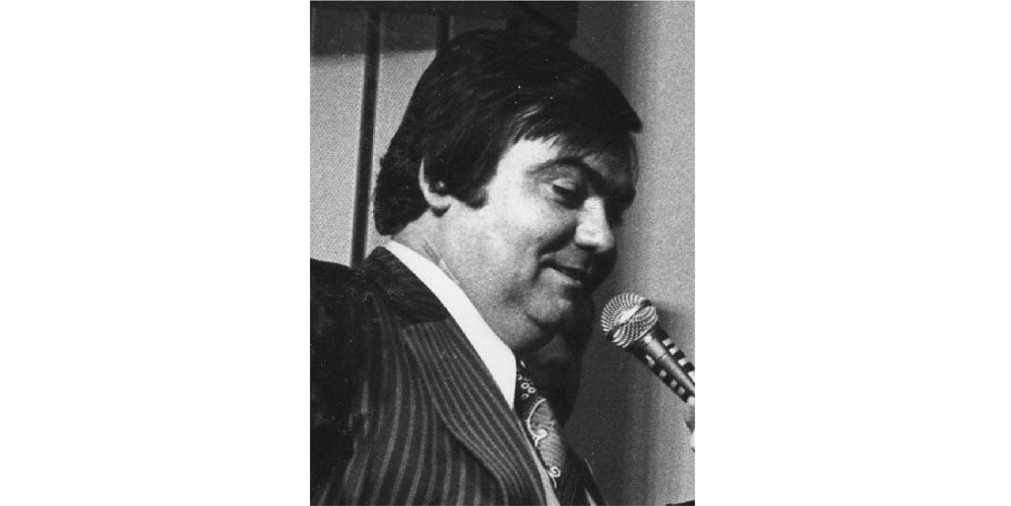 Image en noir et blanc ancienne de Louis Nicollin avec un micro