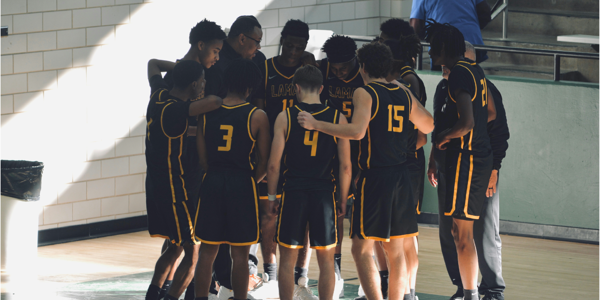 Jeunes joueurs de basketball réunis autour de leur coach lors d'un temps mort